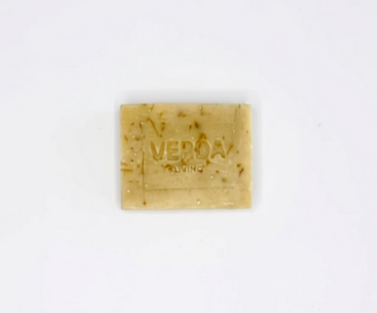 A rectangular bar of citrus VERDA LIVNG soap, featuring a pale orange color with visible brown calendula petals, centered on a plain white background.